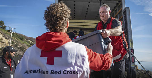 January 24, 2025. Mailbu, Los Angeles, California. American Red Cross unload relief supplies to residents driving through a re-entry check point before returning to their homes. Supplies include PEs (masks, protective body suits, gloves), clean-up kits, tarps, snacks and water. Photo by Jason Colston/American Red Cross